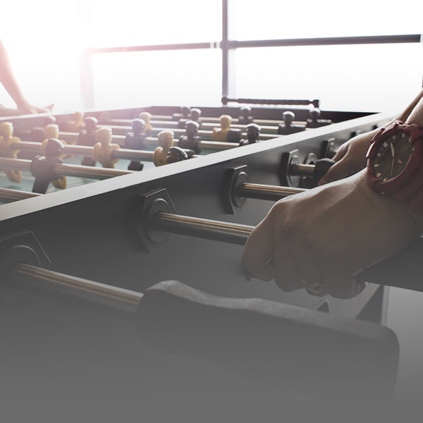 Employees playing foosball on commercial foosball table | R&R Commercial Game Tables Foosball Tables